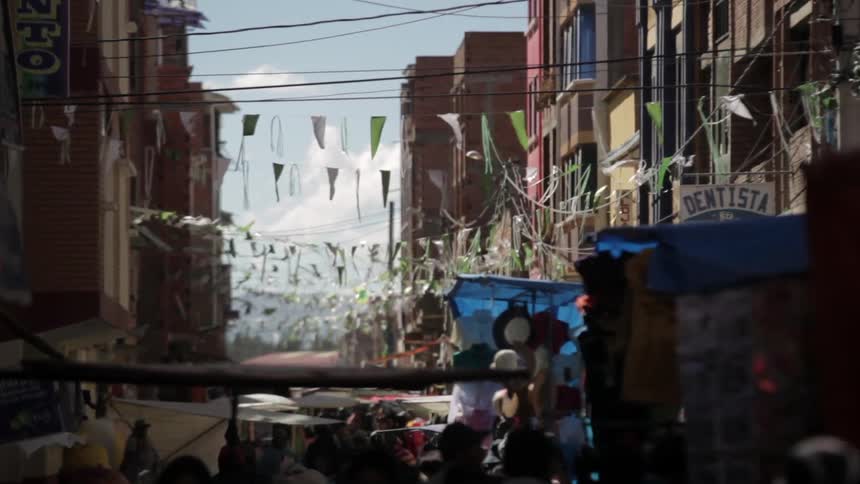 A crowded city street with streamers fluttering in the wind