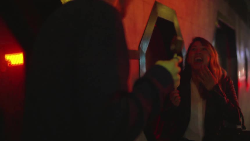 Two people are eating ice cream and talking outside at night