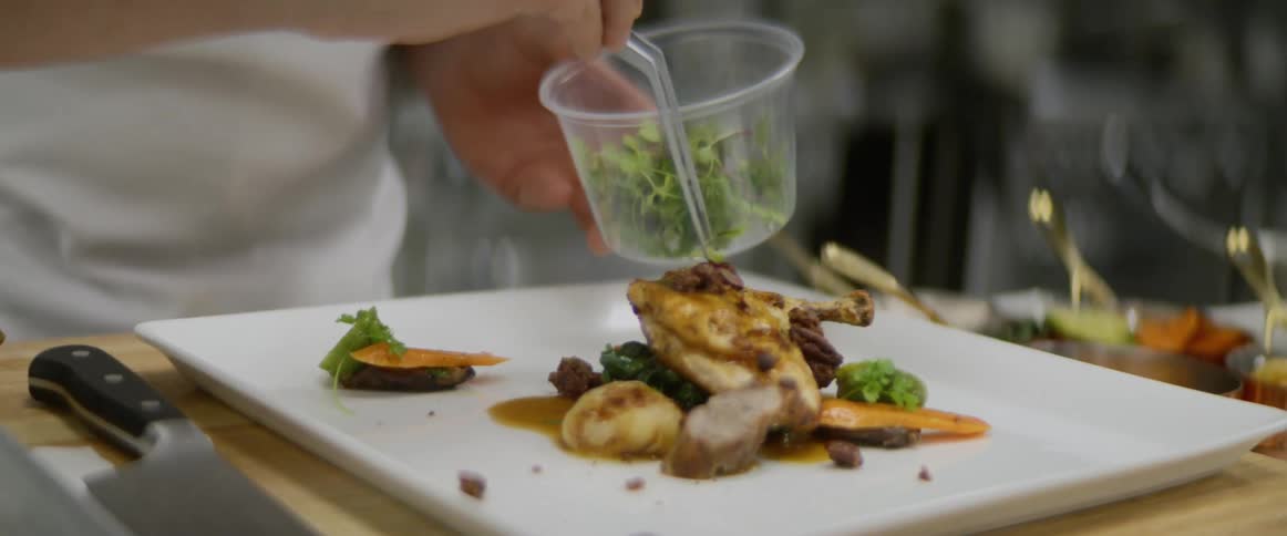A person is serving food with instruments