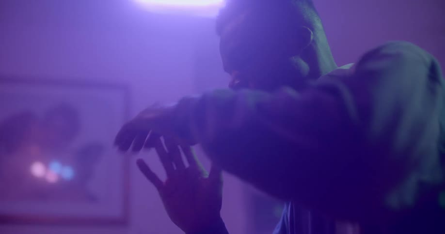 A man is dancing in a room at night