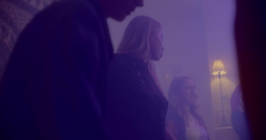 Teens dance in a smoky room with a few lights