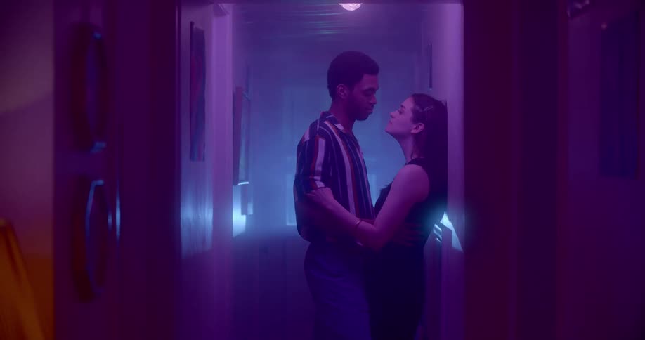 A man and a woman in a hallway hugging