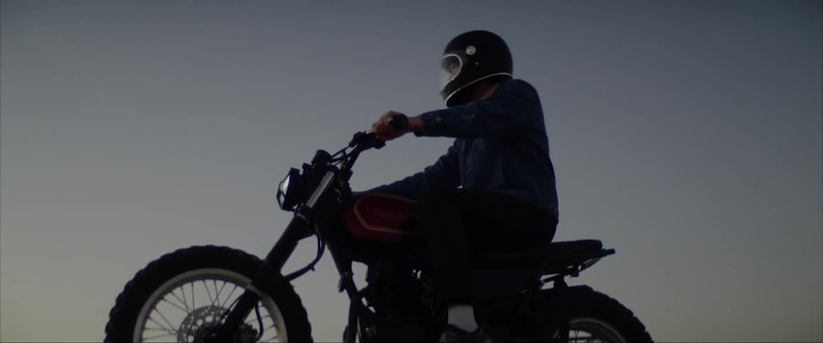 A man sits on a motorcycle