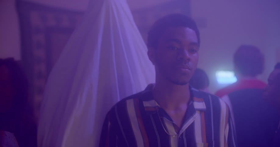 A guy is standing in a club with people