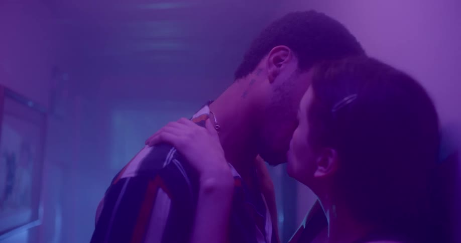 Man and woman kiss in smoky dimly lit hallway
