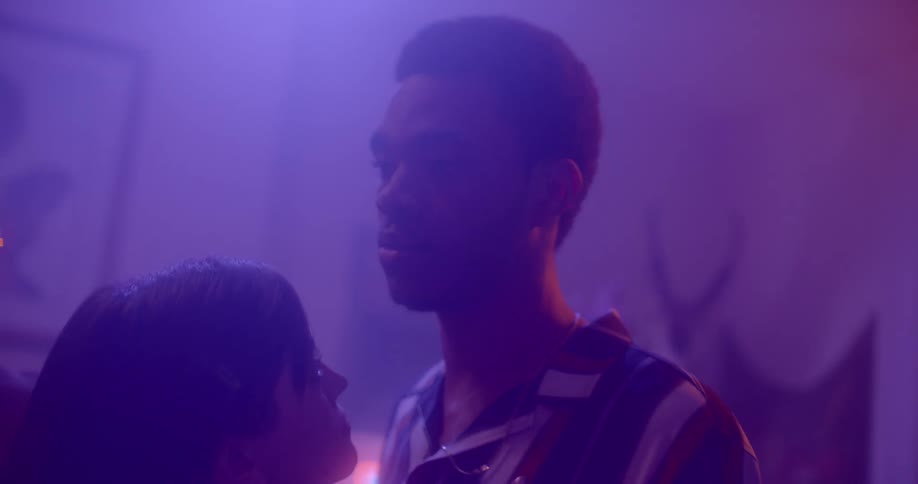 Couple slow dances in smoky purple light tinged room