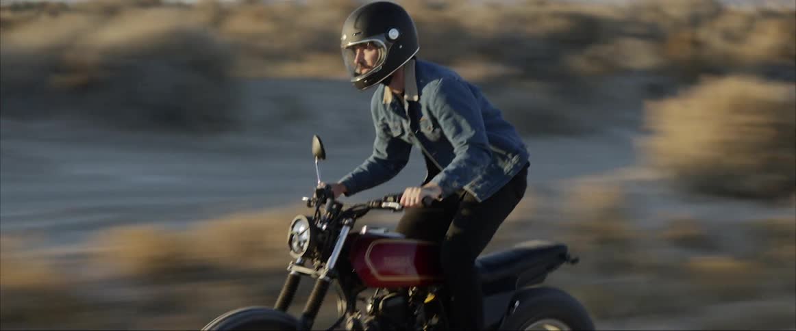 A man rides a dirt bike on a dirt rural road