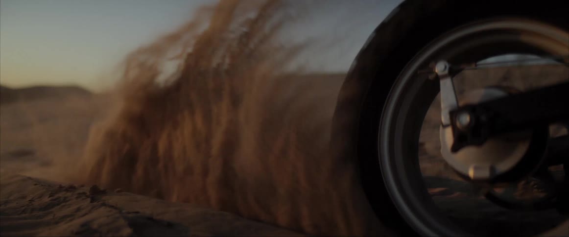 A person is riding a motorcycle through the dirt
