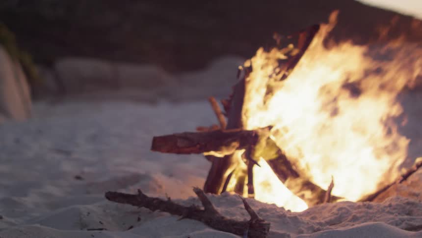 A fire burns on the beach
