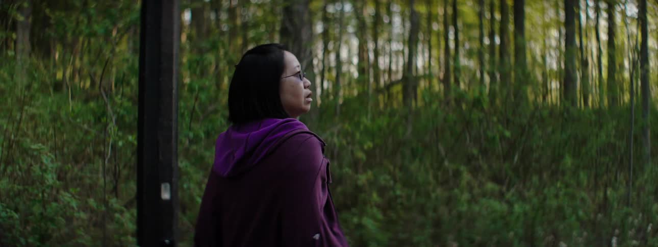 A woman walking along a path through a woodland
