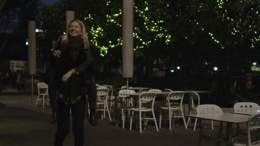 A woman jumps on another woman's back