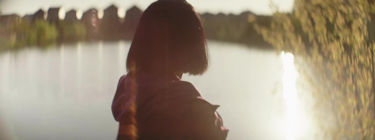 A woman stares into the water
