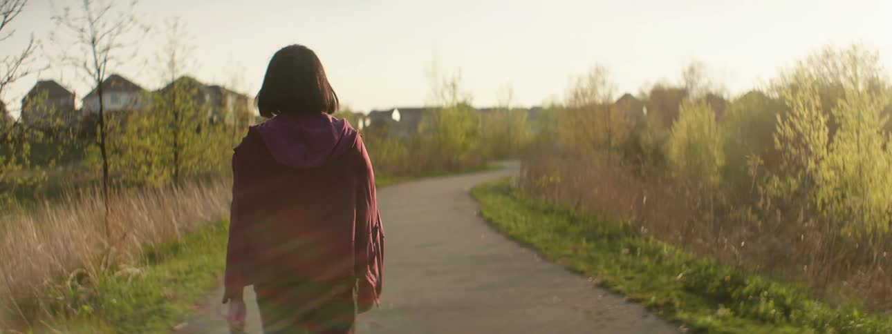 A woman walks down the sidewalk