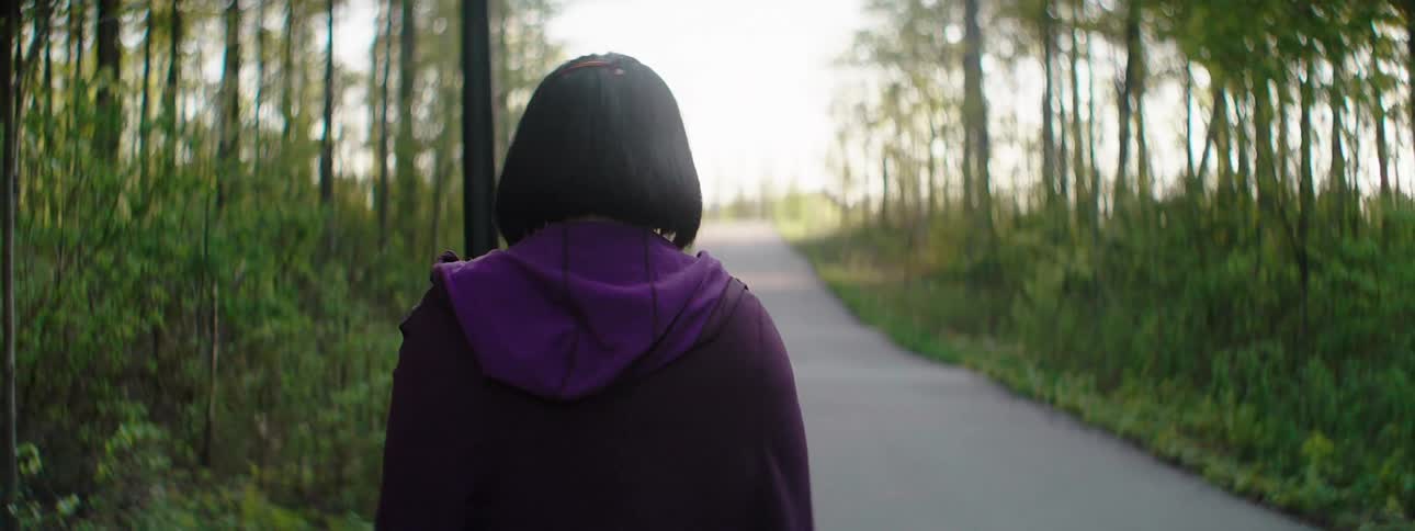 A young asian girl walks along a path