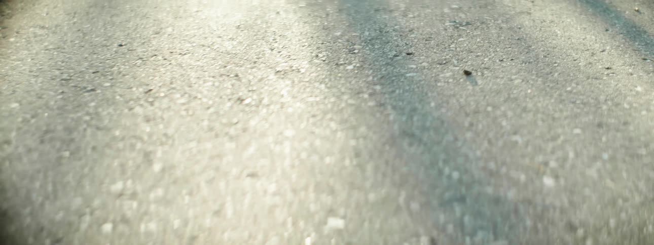 Asphalt road with sun rays falling on it