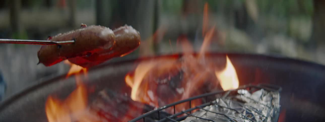 Roasting sausages on an open fire