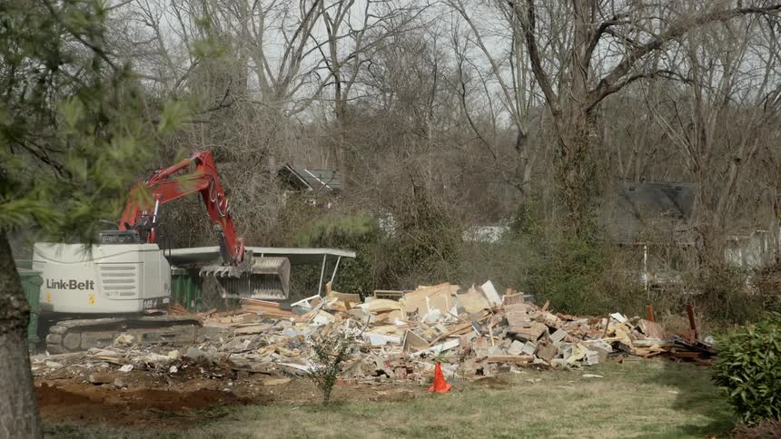 An excavator pulls down part of a structure