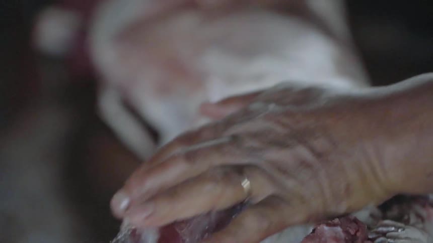 Close up of hands preparing skin of animal meat