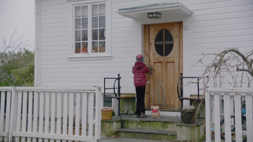 A child rings the bell of a house