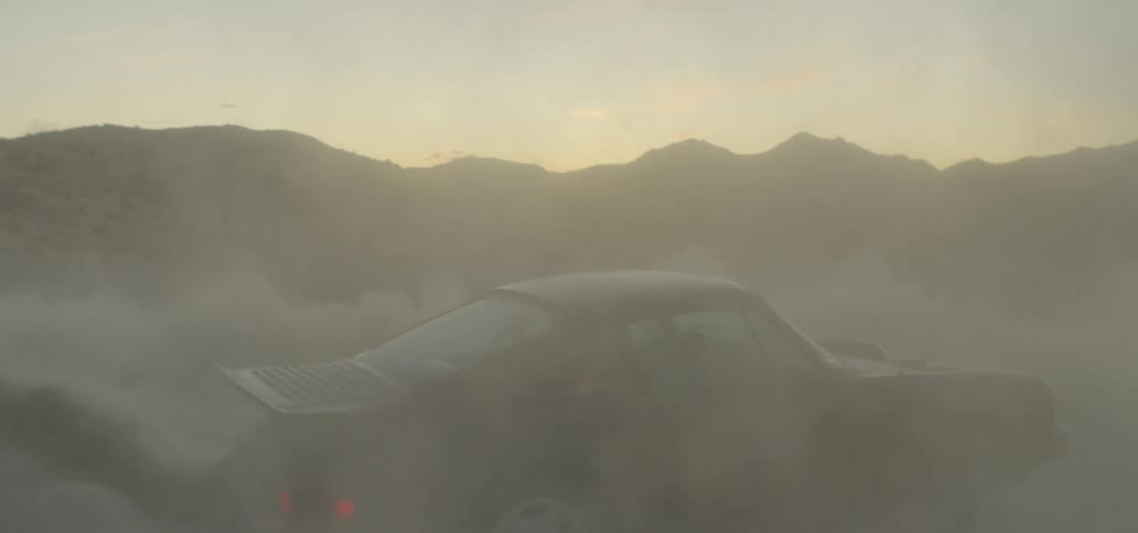 A car spins in circles and kicks up clouds of dirt out in the desert