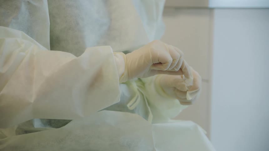 A person with gloves putting a cotton swab in a test tube