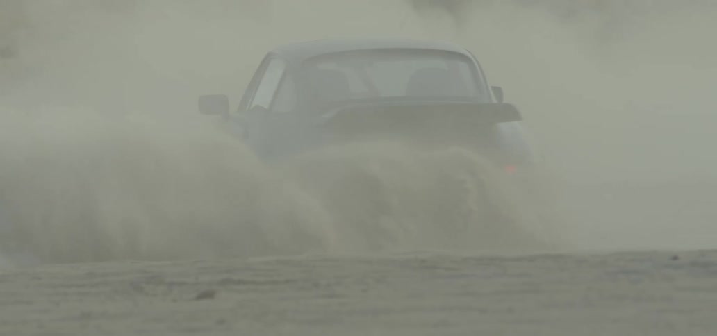 A car slides across the dirt