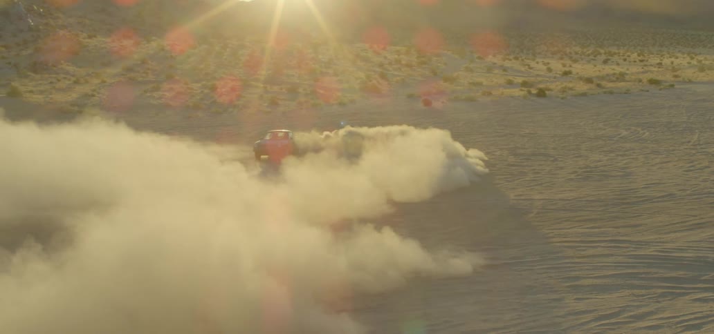 A car driving and skidding in a desert raising dust