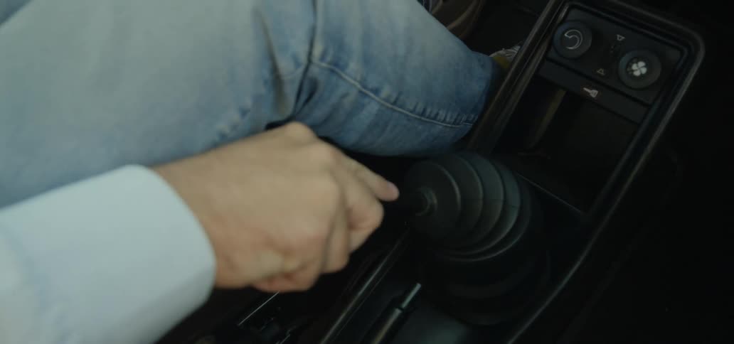 A man in a car shifting gears
