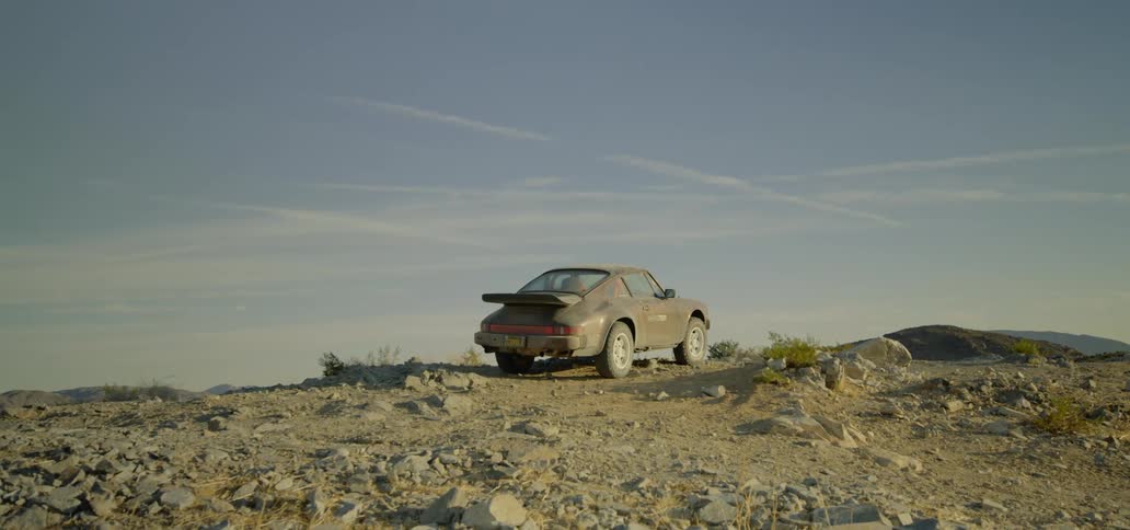 Sports vehicle parks on slightly inclined rocky slope