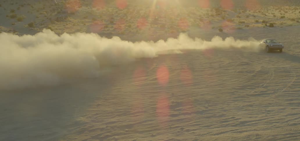 Sports car takes rapid turns and spins through desert