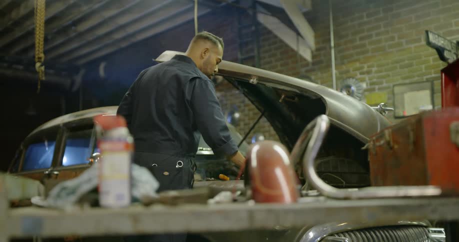 Mechanic works on car in garage