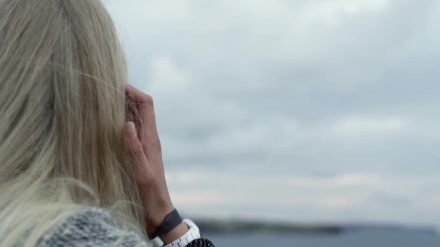 A woman shown from behind staring out to sea