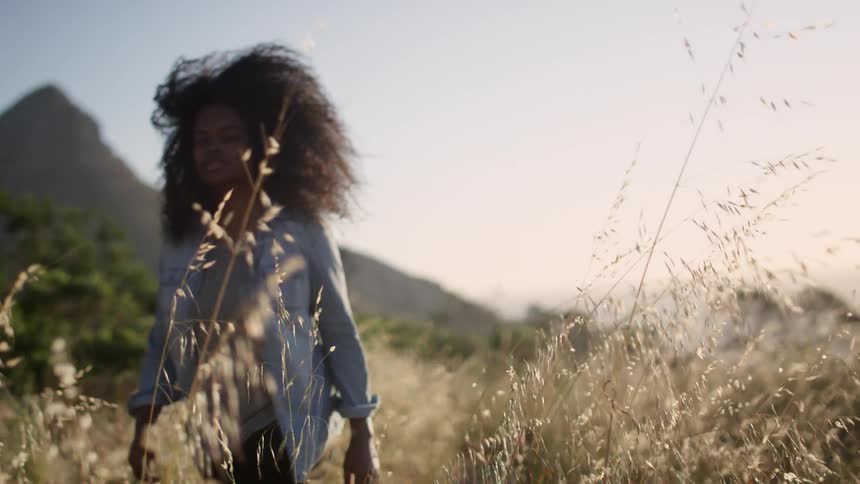 A woman walks through a field in the day time