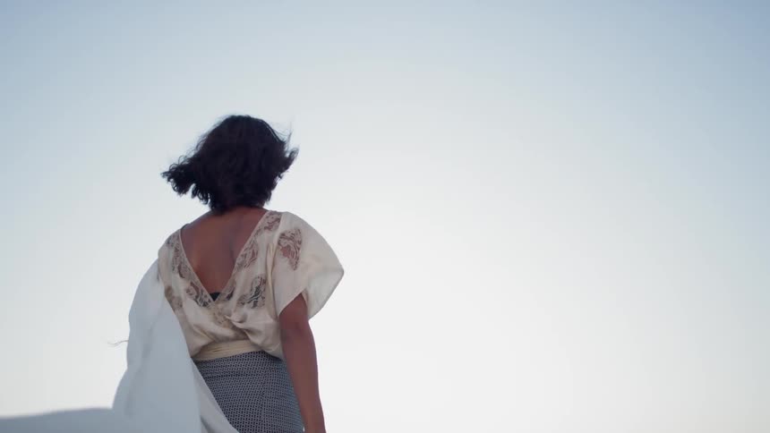 A woman holding a white cloth in the wind