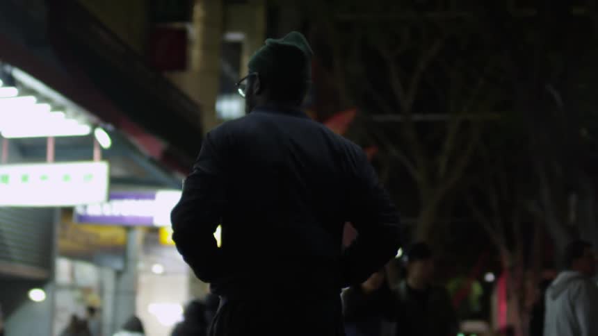 Pedestrians walk on a city street at night