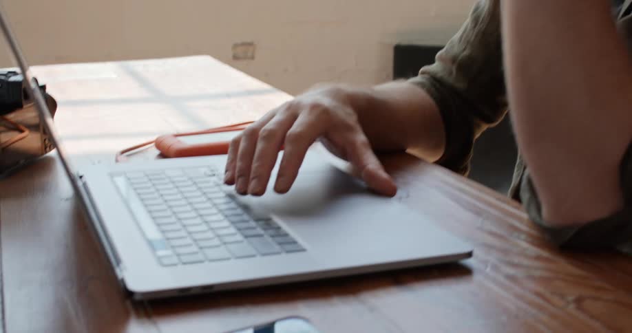 Young man with chin in hand working on laptop computer