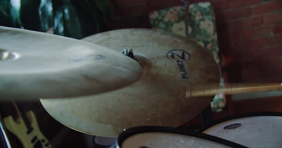 Drummer plays the drums near brick wall