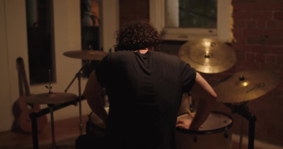 Drummer plays drums in the studio at night