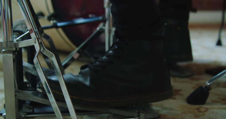 Drummer hits the hi hat foot pedal in the studio