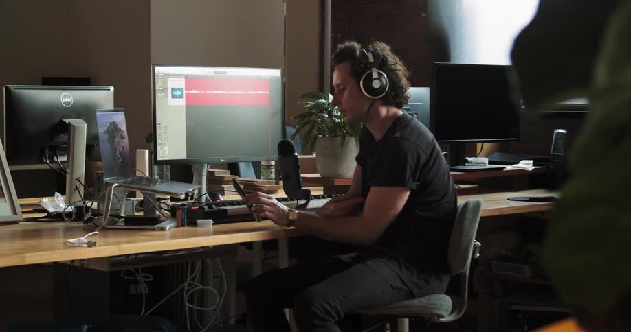 Man sits at table listening to audio play