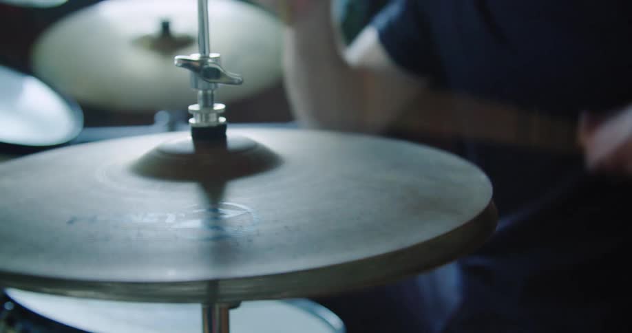 Man wearing a dark t shirt plays the drums