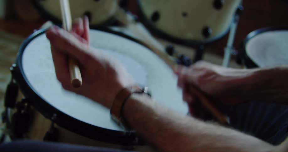 Person wearing a wristwatch drums on drum set