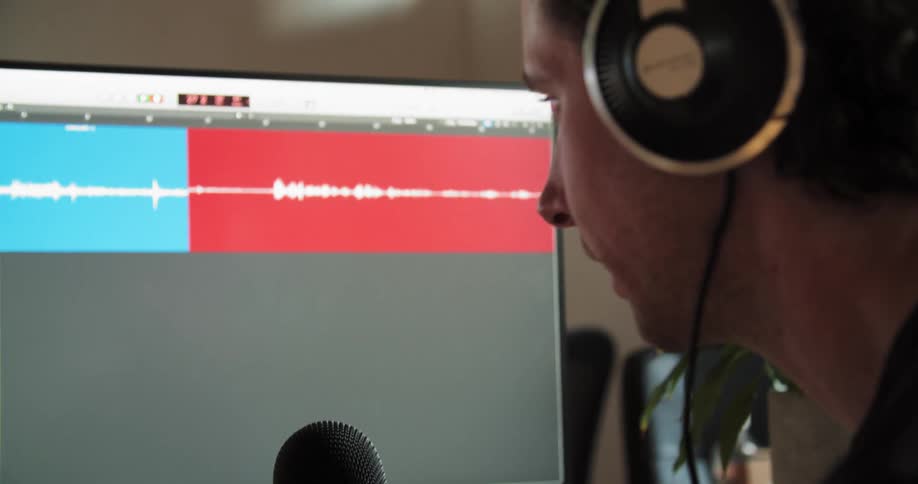 A man is speaking into his microphone at the computer