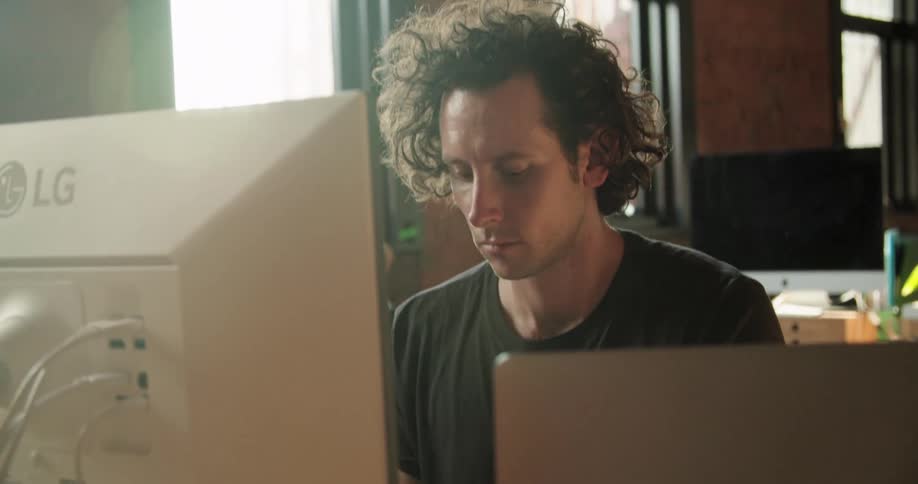 A man plays a keyboard attached to a computer monitor