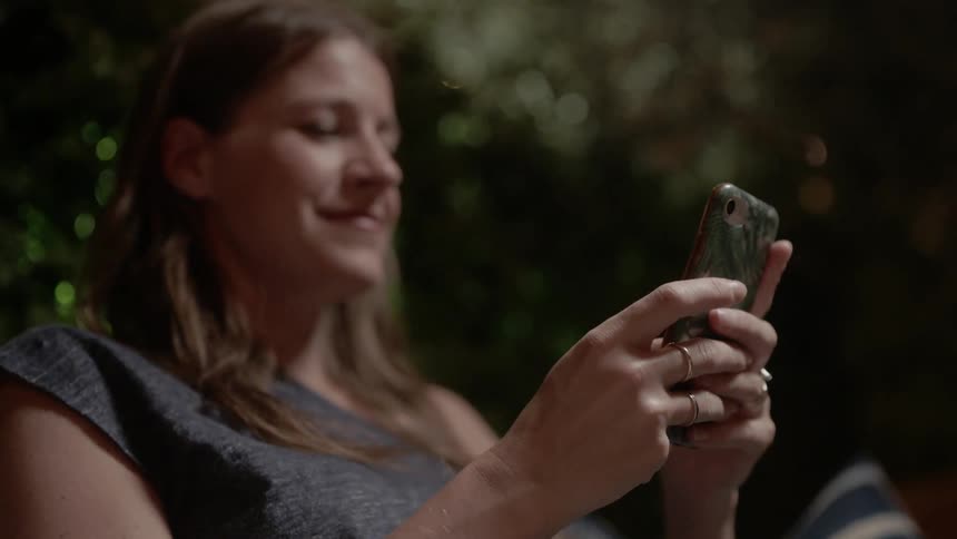 Woman listening to music and texting on her cell phone outdoors
