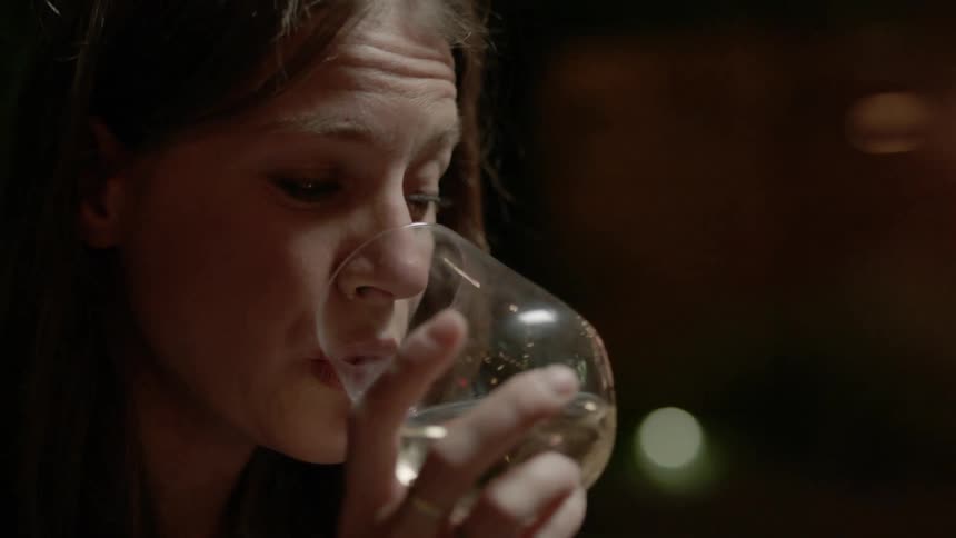 A woman is having a drink at home