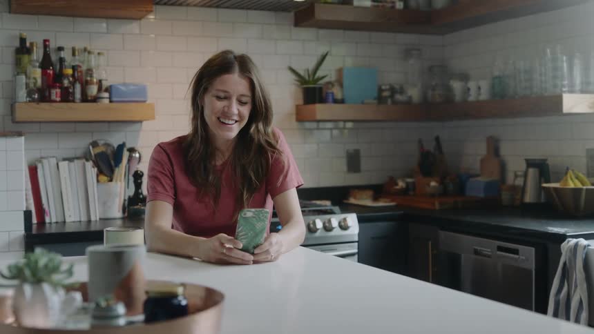 A woman sitting at a table talking on her smart phone