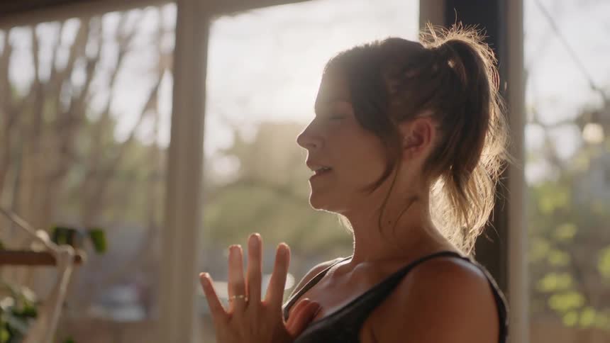 Woman meditates and takes deep breaths in the sunshine