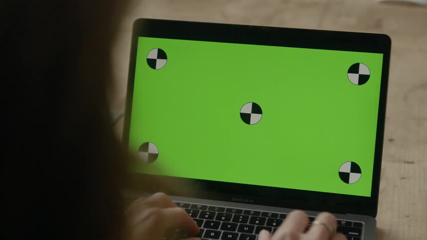 A white woman types on a laptop keyboard