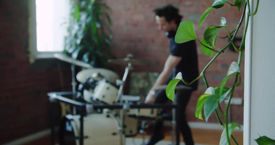 Man walks into room and sits in front of drum set